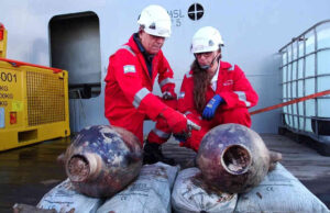 O arqueólogo da IAA Jacob Sharvit ( à esquerda ) e a líder ambiental da Energean, Karnit Bahartan, examinam dois jarros de armazenamento cananeus após serem recuperados do fundo do mar Mediterrâneo em 30 de maio de 2024. 